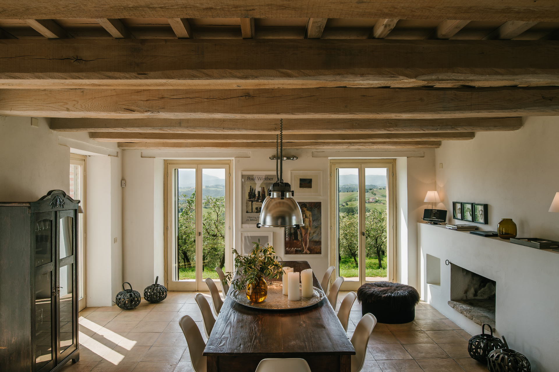Casa Winther dining room with exposed wooden beams, long table and views over the olive grove