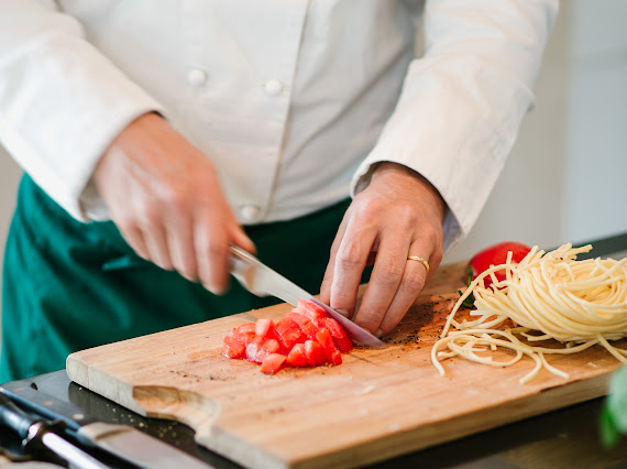 Thomas, private chef, slicing fresh tomatoes next to handmade pasta